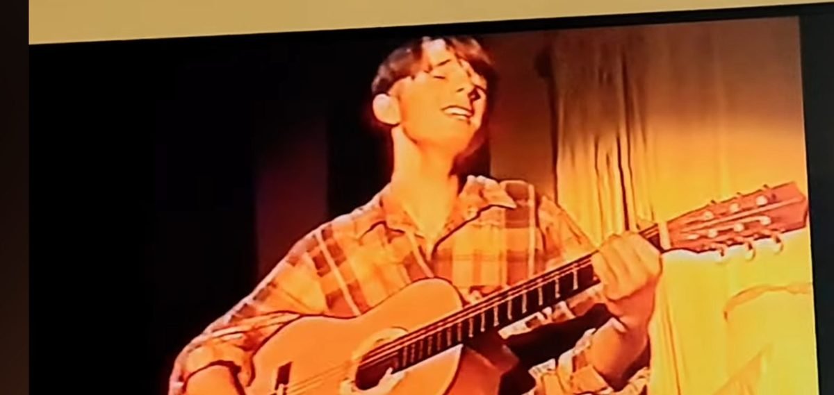 Steven Bailey playing guitar on stage